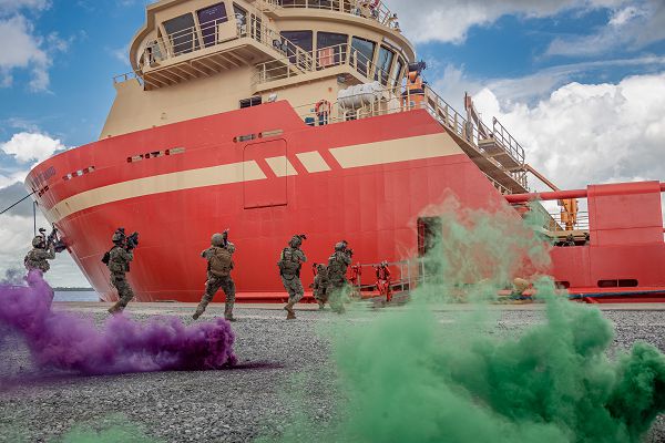 Multinational troops from Guyana, Mexico, Trinidad and Tobago and the U.S. board a vessel moored at a shore base facility for an anti-piracy exercise during TRADEWINDS23 in Georgetown, Guyana, July 24, 2023. This training exercise incorporated volunteers as opposition forces for the four nations to experience operating with real people in a high-stress environment. (U.S. Air National Guard photo by Tech. Sgt. Brigette Waltermire)