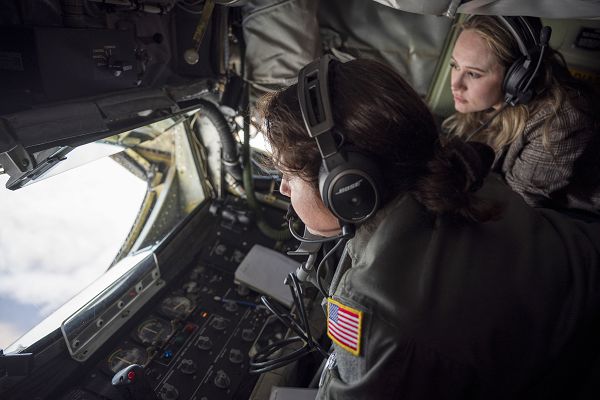 Airman 1st Class Amanda Garcia, left, an in-flight refueling specialist assigned to the 92nd Air Refueling Squadron, performs aerial refueling while a Fairchild Air Force Base spouse watches during a spouse incentive flight near Fairchild AFB, Washington, Dec. 19, 2023. The spouse incentive flight offered the unique view of aerial refueling from a different aircraft as well as a first person view from the boom pod. Spouses play a key role in Air Force missions and operations by supporting our service members at home and abroad. Each squadron at Fairchild has a key spouse team available to help and support spouses and families. (U.S. Air Force photo by Staff Sgt. Ryan Gomez)