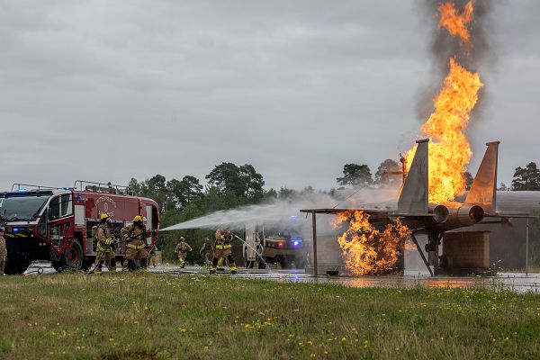 U.S. Air Force Airmen assigned to the 52nd Civil Engineer Squadron, 151st CES and 176th CES put out a controlled fire on an F-15 Eagle replica during an exercise Silver Flag mission qualification course at Ramstein Air Base, Germany, July 27, 2023. Silver Flag teaches members from civil engineer career fields the necessary skills to complete large-scale base recovery and rapid airfield damage recovery operations. (U.S. Air Force photo by Senior Airman Madelyn Keech) 