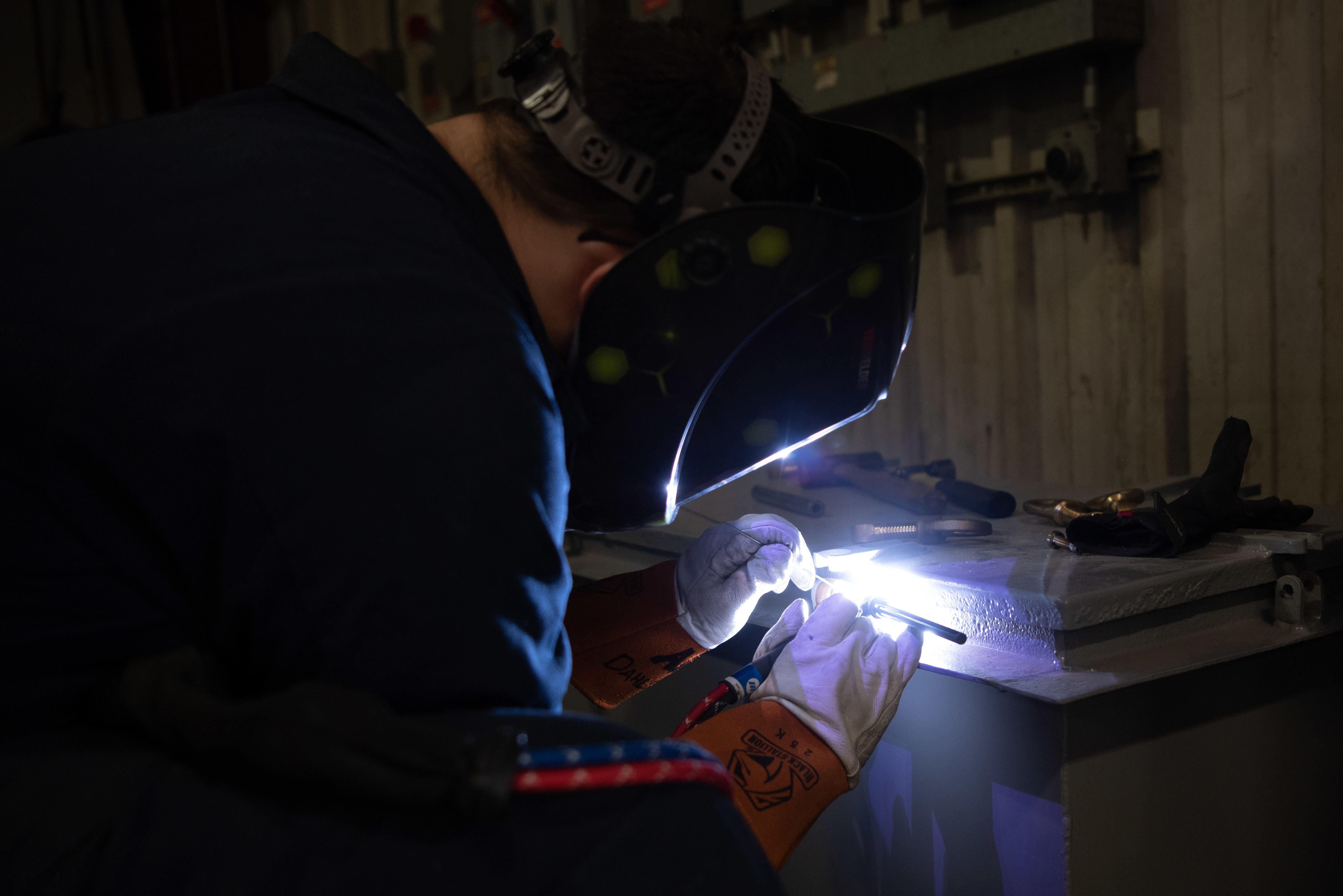 200602-N-ZI768-1097NEWPORT NEWS, Va. (June 2, 2020) Aviation Structural Mechanic 3rd Class Andrew Dahlstrom, assigned to the aircraft intermediate maintenance department aboard the Nimitz-class aircraft carrier USS George Washington (CVN 73), welds a brass dog on a pyrotech junction box at George Washington’s Light Industrial Facility. George Washington is undergoing refueling complex overhaul (RCOH) at Newport News Shipyard. RCOH is a multi-year project performed only once during a carrier’s 50-year service life that includes refueling the ship’s two nuclear reactors, as well as significant repairs, upgrades, and modernization. (U.S. Navy photo by Mass Communication Specialist Seaman Cory J. Daut/ Released)