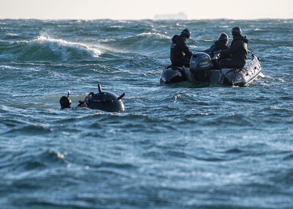 210203-N-ER806-1241ISE BAY, Japan (Feb. 3, 2021)Explosive Ordnance Disposal Technician 3rd Class Benjamin Loell, deployed with Expeditionary Mine Countermeasures Company 1-1, attaches explosives to a training mine during Mine Warfare Exercise (MINEX) 1JA 2021. MINEX 1JA is part of an annual series of exercises between the U.S. Navy and the Japan Maritime Self-Defense Force designed to increase proficiency in mine countermeasure operations. During the nine-day exercise, participants conduct unit-level mine warfare tactics to include mine hunting, detection, and prosecution. (U.S. Navy Photo by Mass Communication Specialist 2nd Class Nick Bauer)