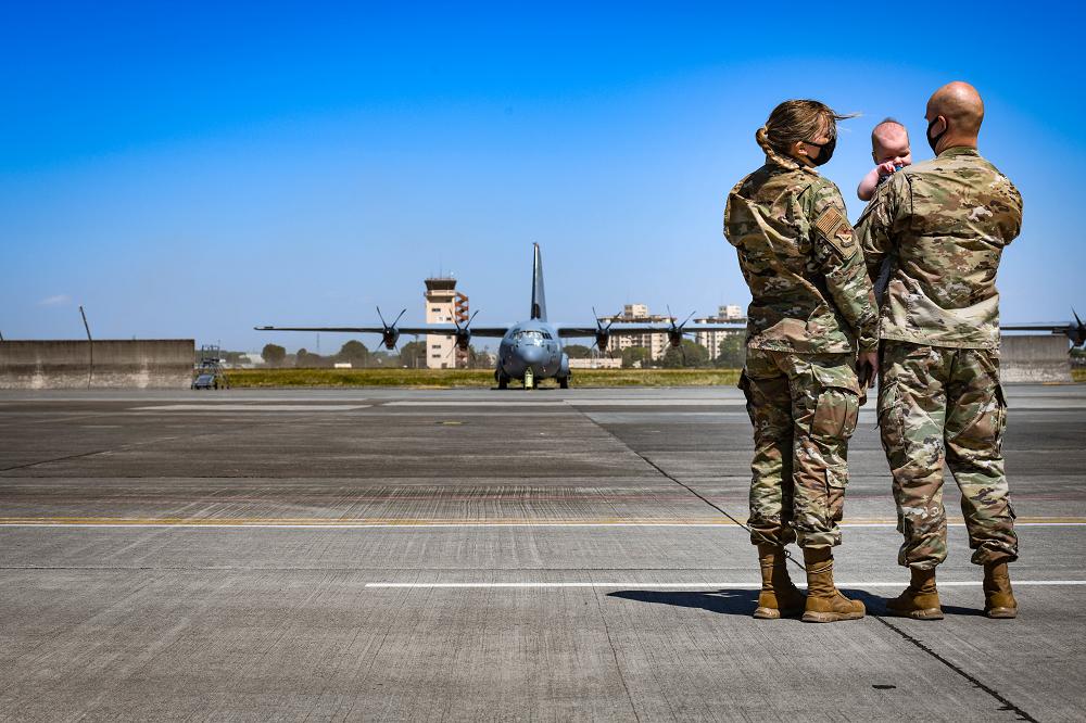 Staff Sgt. Ryann Holzapfel, 374th Airlift Wing Public Affairs craftsman and her husband, Staff Sgt. Brendan Miller, Armed Forces Network Tokyo broadcaster, stand on the Yokota flight line with their six-month-old son at Yokota Air Base, Japan, April 26, 2021. Holzapfel and Miller plan on visiting the U.S. in the near future to introduce their son to their families in person for the first time. (photo by Staff Sgt. Kyle Johnson)